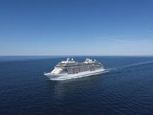 A large cruise ship sails smoothly across a vast blue ocean A large cruise ship sails smoothly across a vast blue ocean