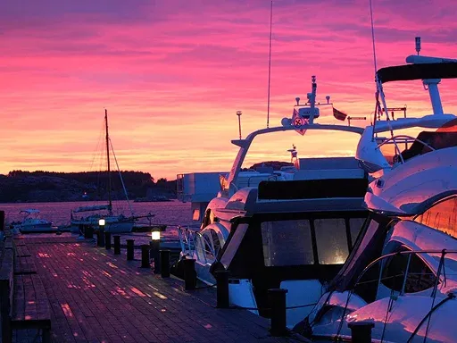 Vibrant sunset casts pink and purple hues over moored yachts Vibrant sunset casts pink and purple hues over moored yachts